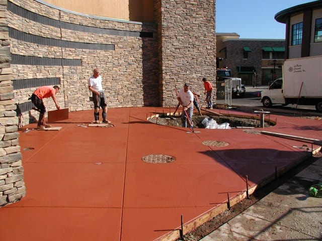 The Davis Colors' Brick Red concrete pigment at the Bridgeport Village Shopping Center located in Tigard, Oregon is being finished by the concrete finishers