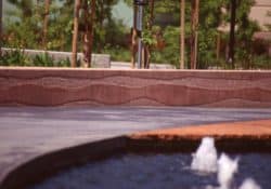 Cisco Systems' Campus - The walkway was colored with Davis Colors' Dark Gray (860) concrete color.  The walls were colored with Davis Colors Brick Red and 1117 at 5 lbs per sack of cement.  The walls all had varying degrees of exposure created by sand blasting the surface.   The concrete had varying levels of concrete colors to achieve the random look of a washed out terrain.