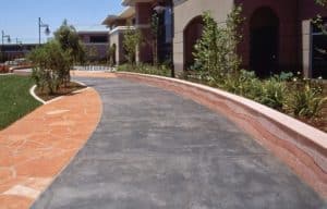 Cisco Systems' Campus - The walkway was colored with Davis Colors' Dark Gray (860) concrete color. The walls were colored with Davis Colors Brick Red and 1117 at 5 lbs per sack of cement. The walls all had varying degrees of exposure created by sand blasting the surface. The concrete had varying levels of concrete colors to achieve the random look of a washed out terrain.