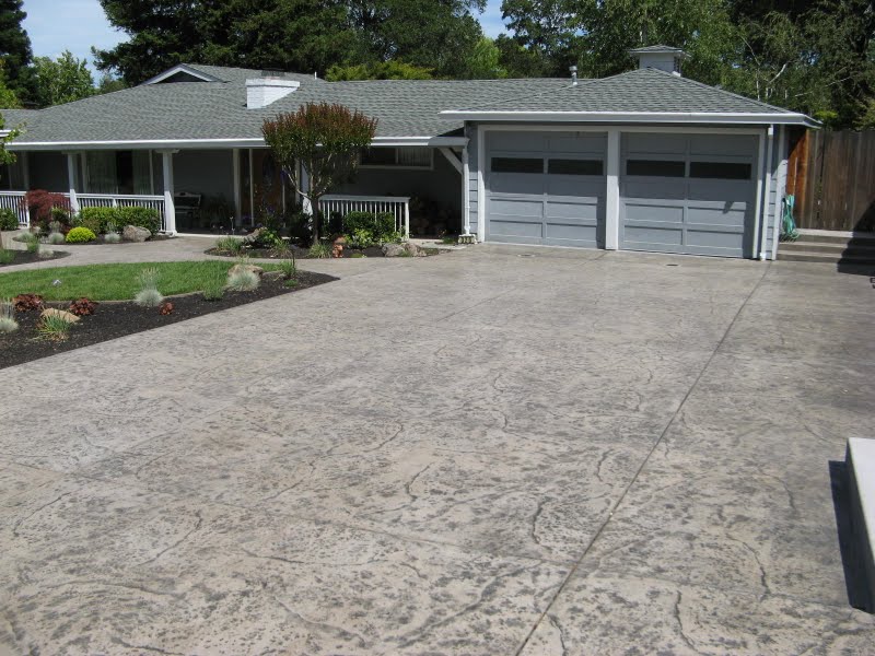 This stamped concrete driveway was integally colored with Davis Colors' Outback. A rough stone texture was used with a medium gray colored dust on release agent. The gray accent color (release) was selected to blend in with the paint color of the home providing harmony between the home and hardscape.  For more information about this project go to www.eastrocklandscape.com or give Eastrock Landscape a call at 925-828-2181.  - www.daviscolors.com