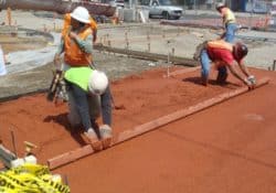 The concrete contractors are screeding the concrete.