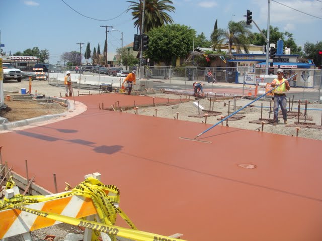 The colored concrete is being floated to level the concrete. Concrete pigment is the Brick Red product from Davis Colors
