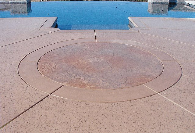 This decorative concrete stamped pool deck that was colored with Davis Colors Sandstone www.daviscolors.com.  For the stamped portion they used an old granite pattern with a light gray and mesa buff release agent.