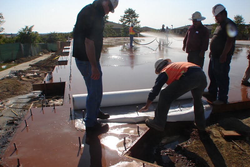 The wet curing process begins with covering the surface of the concrete with a 1/8” to 1/4” layer of water.  Here the contractors are starting to roll out McTech Group’s UltraCure NCF™ curing blanket.  This curing method is designed to provide thorough hydration and even curing.