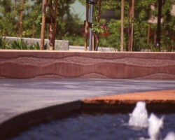 Cisco Systems' Campus - The walkway was colored with Davis Colors' Dark Gray (860) concrete color. The walls were colored with Davis Colors Brick Red and 1117 at 5 lbs per sack of cement. The walls all had varying degrees of exposure created by sand blasting the surface. The concrete had varying levels of concrete colors to achieve the random look of a washed out terrain.