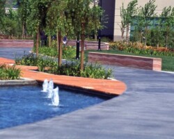 Cisco Systems' Campus - The walkway was colored with Davis Colors' Dark Gray (860) concrete color. The walls were colored with Davis Colors Brick Red and 1117 at 5 lbs per sack of cement. The walls all had varying degrees of exposure created by sand blasting the surface. The concrete had varying levels of concrete colors to achieve the random look of a washed out terrain.