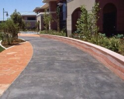 Cisco Systems' Campus - The walkway was colored with Davis Colors' Dark Gray (860) concrete color. The walls were colored with Davis Colors Brick Red and 1117 at 5 lbs per sack of cement. The walls all had varying degrees of exposure created by sand blasting the surface. The concrete had varying levels of concrete colors to achieve the random look of a washed out terrain.