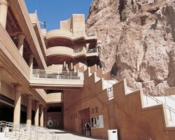 The Hoover Dam parking structure is a cast-in-place structure using pan slab forming. It is tucked inside a steep ravine that has been partially blasted out to provide enough room for the structural footprint. Stretching 540 ft. in length in a stepped down configuration, the structure is 165 ft. wide and three levels high at the rear, 215 ft. wide and five levels high in front. The structure’s concrete is integrally colored to blend in with the surroundings canyon rock. As an added step to achieve the proper color blending, the structural concrete was subsequently sandblasted to etch its surface and reduce the sheen. To learn more about the Hoover Dam visit the Bureau of Reclamation website – www.usbr.gov/lc/hooverdam/index or Wikipedia at http://en.wikipedia.org/wiki/Boulder_Canyon_Project#Planning_and_agreements .