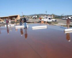 The wet curing process begins with covering the surface of the concrete with a 1/8” to 1/4” layer of water. Here the contractors are starting to roll out McTech Group’s UltraCure NCF™ curing blanket. This curing method is designed to provide thorough hydration and even curing. To learn more about UltraCure NCF™ go to http://www.mctechgroup.com/wc_train.html. UltraCure NCF™ is a registered trademark of McTech Group Inc. The concrete is colored with Davis Colors’ concrete color www.daviscolors.com.
